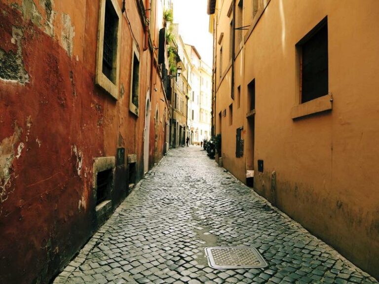 Ruelle pavée entre bâtiments anciens en Italie.