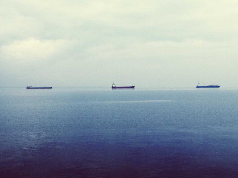 Trois cargos naviguant sur une mer calme.